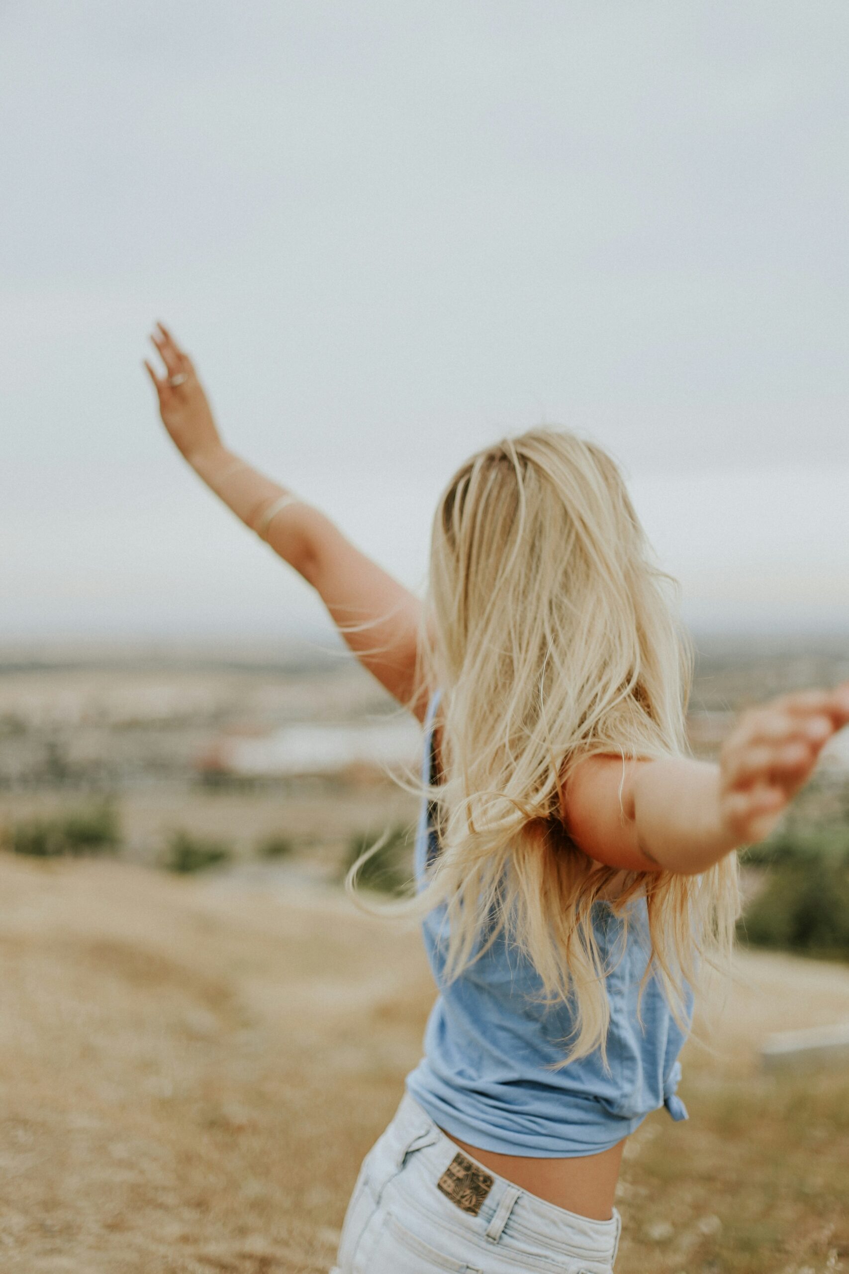 girl holding her arms out wide on the beach